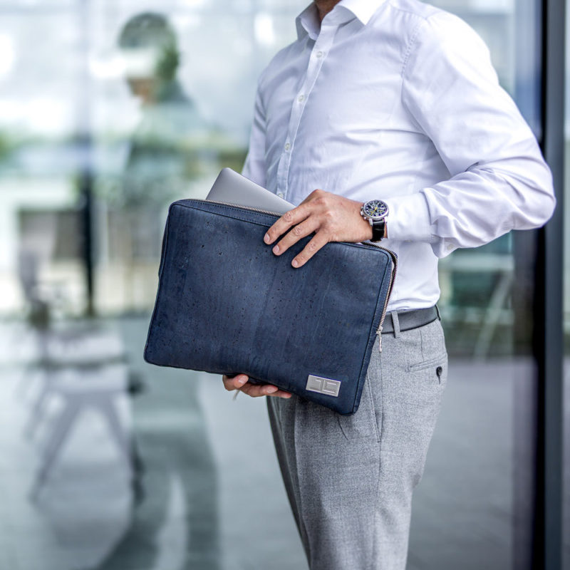 Business Geschäftsmann holt sein Tablet aus dunkelblauer LUCA Laptophülle aus Kork von Jorge Carmo